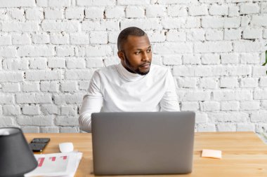 Ofisinde dizüstü bilgisayarı olan Afrikalı Amerikalı serbest yazar.