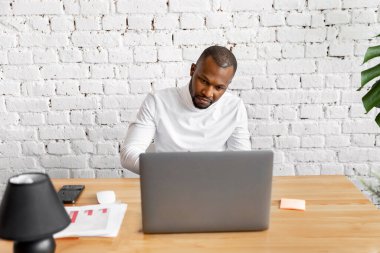 Ofisinde dizüstü bilgisayarı olan Afrikalı Amerikalı serbest yazar.