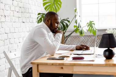 Ofisinde dizüstü bilgisayarı olan Afrikalı Amerikalı serbest yazar.