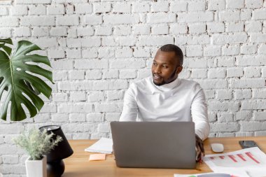 Ofisinde dizüstü bilgisayarı olan Afrikalı Amerikalı serbest yazar.
