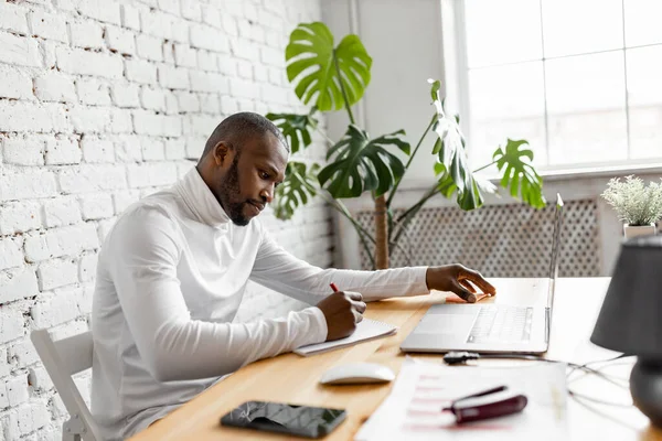 Ofisinde dizüstü bilgisayarı olan Afrikalı Amerikalı serbest yazar.