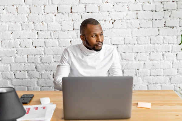 Ofisinde dizüstü bilgisayarı olan Afrikalı Amerikalı serbest yazar.