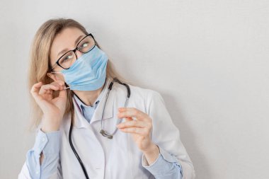 Tıbbi maskeli genç bir kadının portresi. 