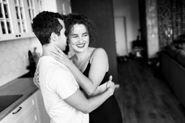 Mutlu çiftin sarılıp öpüşmelerinin siyah beyaz portresi.