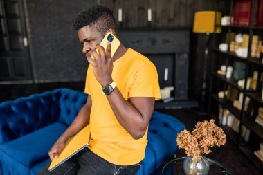 Afrikalı Amerikalı adam cep telefonuyla konuşuyor. 