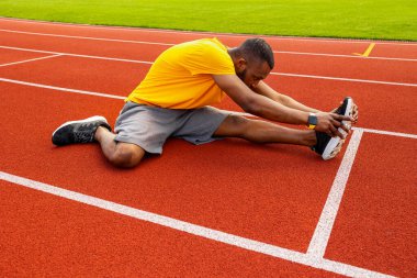 Genç formda adam stadyumda geriniyor. 