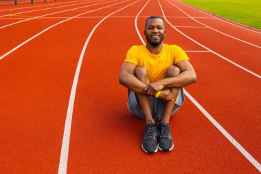 Genç formda adam stadyumda geriniyor. 