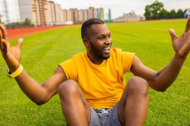 Genç Afrikalı Amerikalı adam stadyumda kutlama yapıyor. 