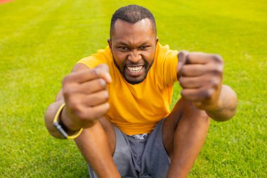 Genç Afrikalı Amerikalı adam stadyumda kutlama yapıyor. 