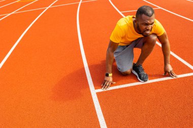 Stadyumda koşan genç formda bir adam 