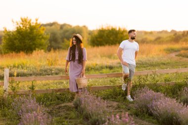 Aşık genç çift gün batımında tarlada dinleniyor. 