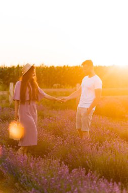 Aşık genç çift gün batımında tarlada dinleniyor. 
