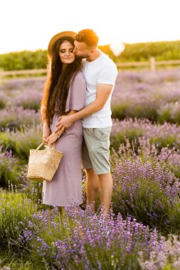 Aşık genç çift gün batımında tarlada dinleniyor. 