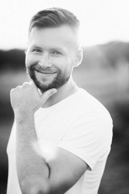 Tarlada poz veren sakallı genç adam. 