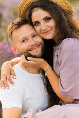 Aşık genç çift gün batımında tarlada dinleniyor. 