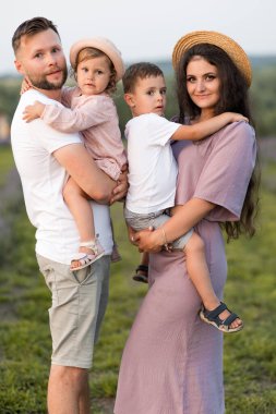 Parkta küçük çocukları olan mutlu bir aile.