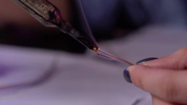 Elektrikçi elleri yakın. Usta profesyonel olarak lehim makinesi ve kablolarla çalışır. Sanatçı bir neon tabela yaratır..