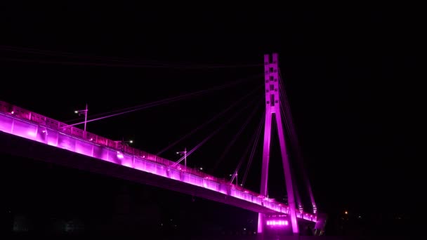 Il ponte LED di Tyumen è illuminato di notte in rosa. Ponte al neon degli innamorati sull'argine della città moderna. — Video Stock