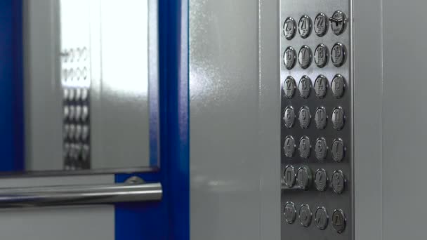 엘리베이터 문이 열려 있어요. 플로어 넘버 버튼 클로즈업 , 4k 비디오. 거울이 있는 새로운 금속 엘리베이터가 문을 열고 닫는다. — 비디오