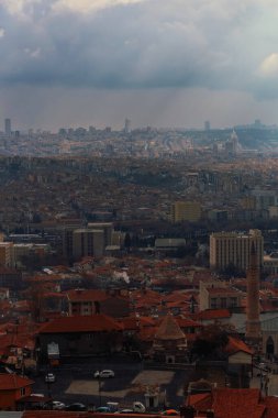 Ankara 'da kırmızı çatılı eski evlerin manzarası. Türkiye 'deki konut binaları üzerinde sağanak bulutlar.