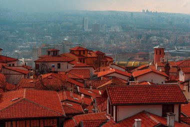 Ankara 'da kırmızı çatılı eski evlerin manzarası. Türkiye 'deki konut binaları üzerinde sağanak bulutlar.