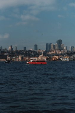İstanbul 'daki Boğaz Körfezi' nde kırmızı bir yolcu gemisi yol alıyor.