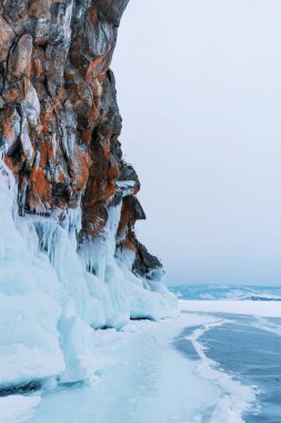Baykal Gölü, kış günü. Olkhon Adası 'ndaki yüksek uçurumlar. Büyük buz blokları dağların eteklerini kaplıyor..