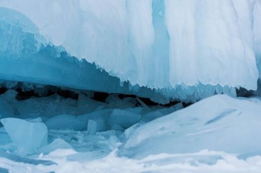 Buz mağarasının ayağı. Güzel renkli buz saçakları kayayı kaplıyor..