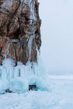 Baykal Gölü, kış günü. Olkhon Adası 'ndaki yüksek uçurumlar. Büyük buz blokları dağların eteklerini kaplıyor..