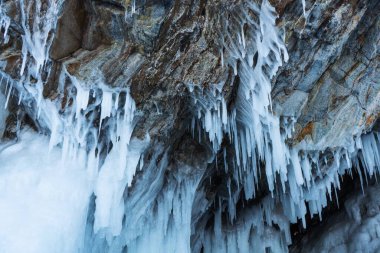 Buzla kaplı harika bir kaya. Buz gibi mağara Baykal Gölü üzerindeki büyük buz saçaklarıyla kaplı..