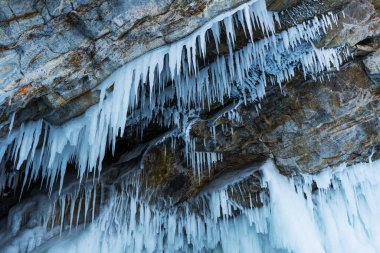 Buzla kaplı harika bir kaya. Buz gibi mağara Baykal Gölü üzerindeki büyük buz saçaklarıyla kaplı..