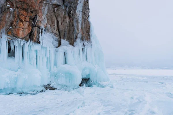 Baykal Gölü, kış günü. Olkhon Adası 'ndaki yüksek uçurumlar. Büyük buz blokları dağların eteklerini kaplıyor..