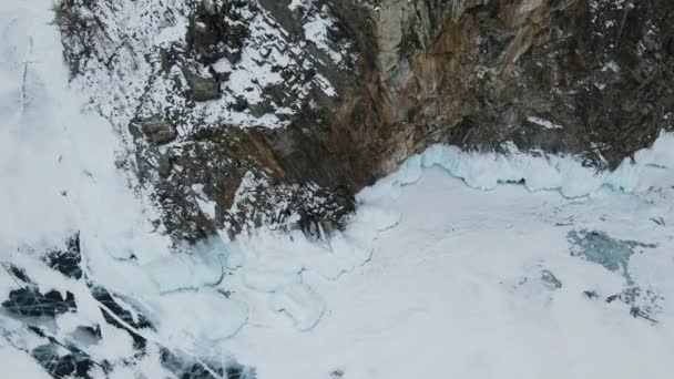 岩石的脚被美丽的蓝冰覆盖着 贝加尔湖的冬天冰冷的湖面 冰封着深深的裂缝 — 图库视频影像
