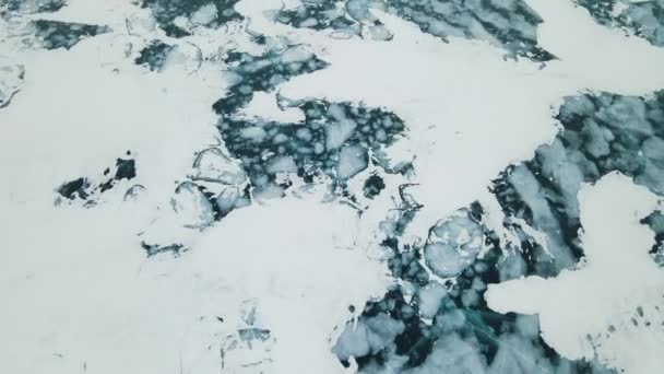 湖上蓝色透明的冰部分被雪覆盖着 贝加尔湖深层裂缝的美丽鸟瞰 — 图库视频影像
