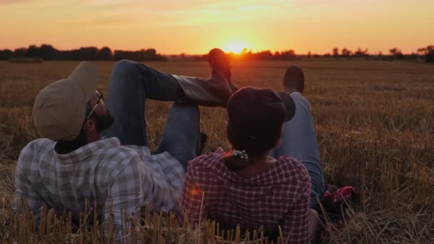 Un par de granjeros descansan en el campo después de la cosecha — Vídeo de stock