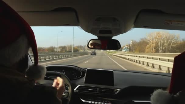 Vater und Tochter in Nikolausmützen, Auto fahren, Lieder singen — Stockvideo