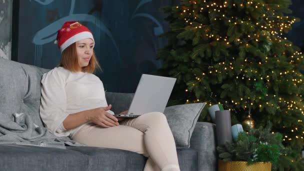 Νεαρή γυναίκα που έχει μια βιντεοκλήση στο διαδίκτυο την παραμονή των Χριστουγέννων — Αρχείο Βίντεο