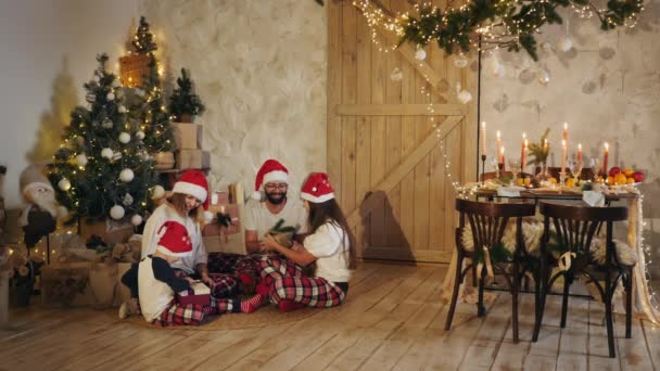 Familia de cuatro dando regalos en casa en Navidad — Vídeos de Stock