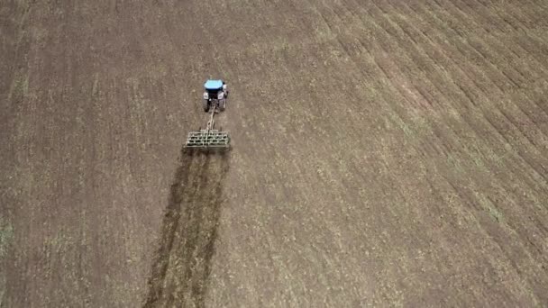 Luchtfoto van een trekker met een cultivator die in het veld werkt — Stockvideo