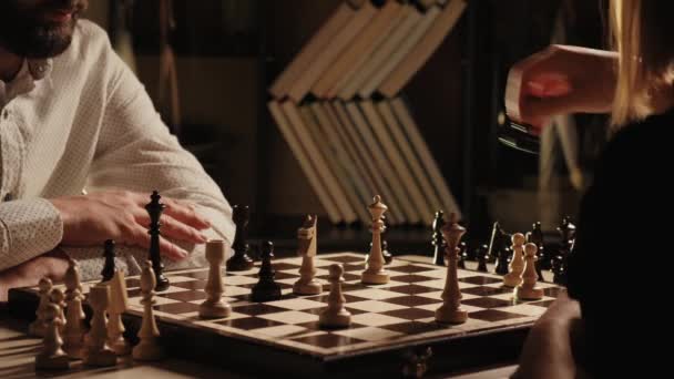 Genç adam ve kadın kapalı alanda satranç oynuyorlar. — Stok video