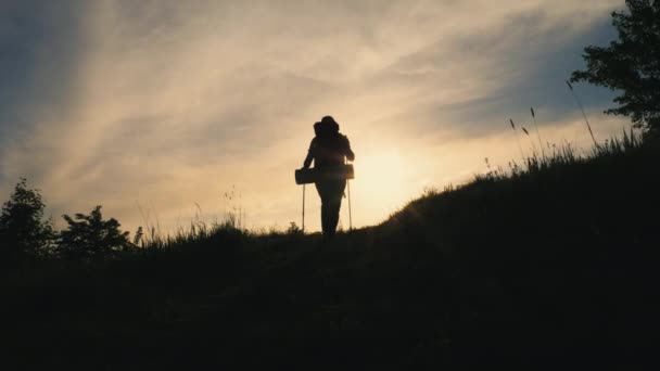 Achteraanzicht silhouet van wandelende man met rugzak op de berg — Stockvideo