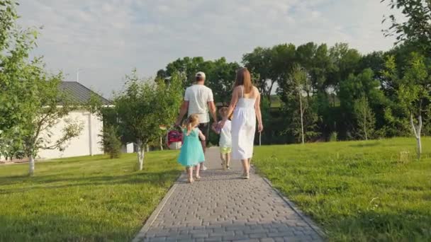 Вид сзади на семью с детьми, которые собираются на пикник и веселятся вместе — стоковое видео