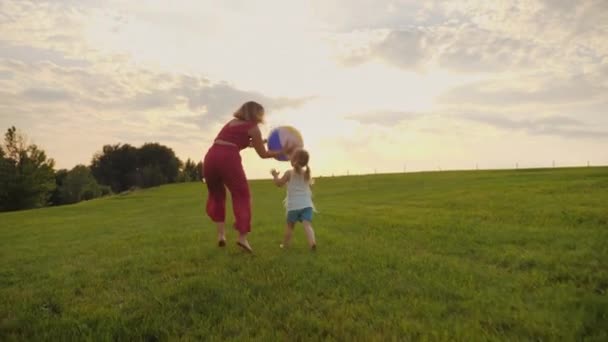 Junge Mutter spielt mit Ball lustig mit ihrer kleinen Tochter — Stockvideo