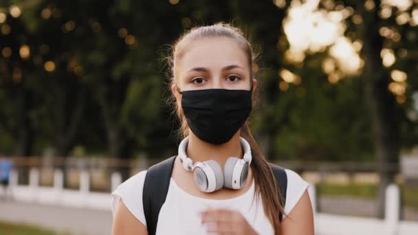 Happy girl takes off black protective mask from face — Stock video