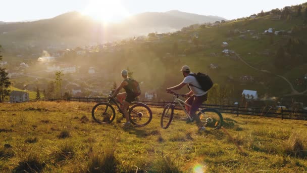 Familie paar fietsers rijden in de bergen — Stockvideo