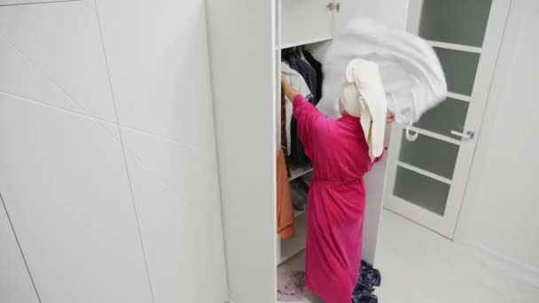 Mujer molesta tirando la ropa del armario — Vídeos de Stock