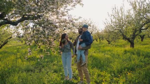 Успішний фермер чоловічої статі з дітьми в квітковому яблучному саду — стокове відео