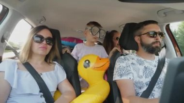 Çocuklar arabada arka koltuklarda otururken denizde seyahat etmekten mutlu olurlar.