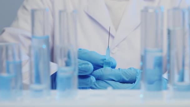 Ο γιατρός κρατά μια σύριγγα με ένα εμβόλιο, σε πρώτο πλάνο ένα δοκιμαστικό σωλήνα — Αρχείο Βίντεο