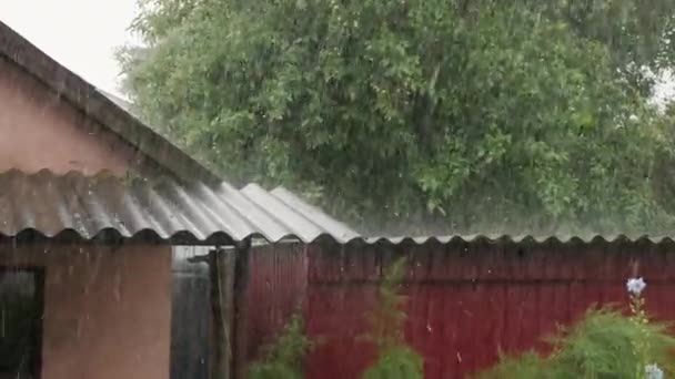 Важкий дощ з градом потрапляє на дахи будинків — стокове відео